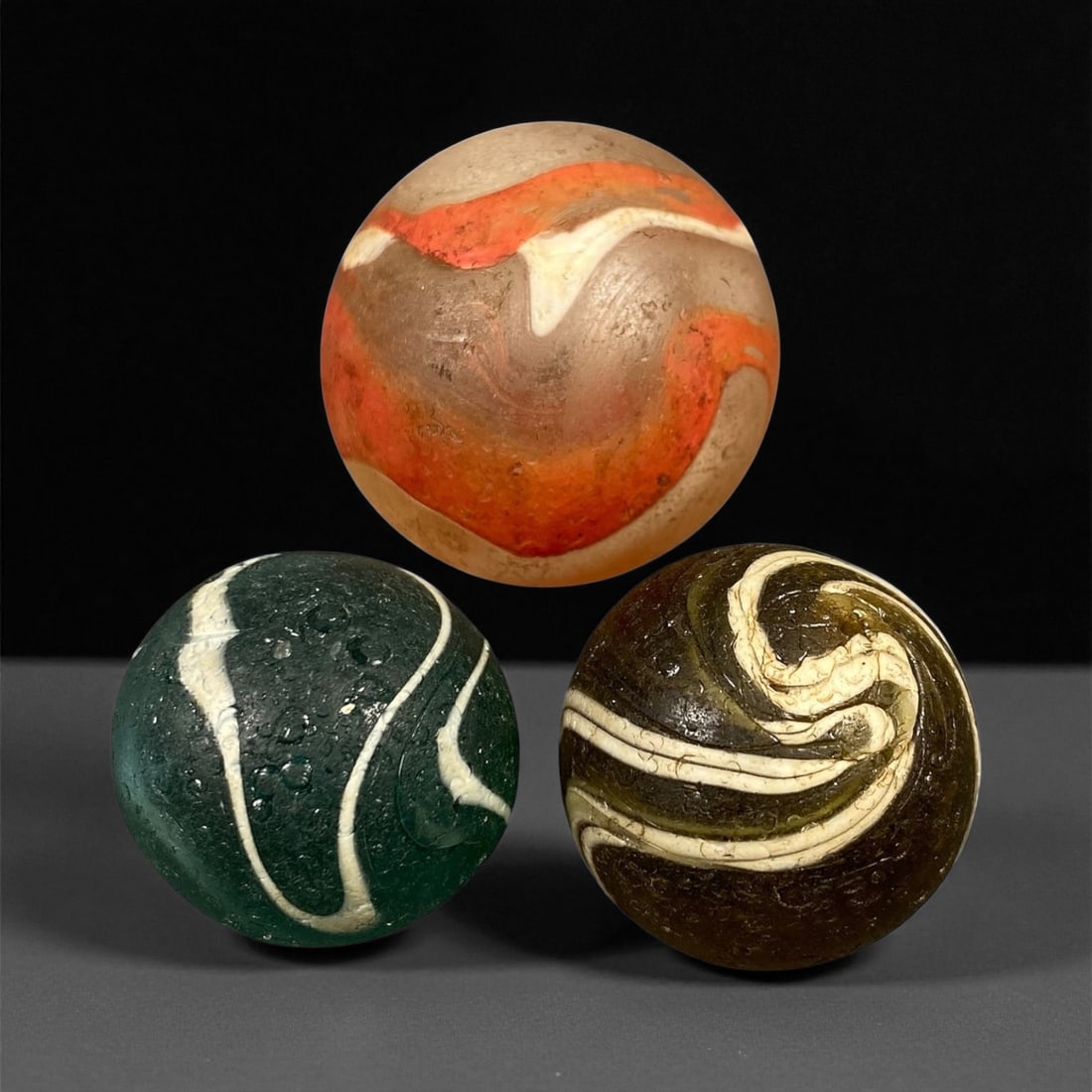 Vintage Glass Marbles Lot, Mid-20th Century, 2.5-3.4cm: This charming lot of vintage glass marbles, dating from the mid-20th century, reflects the artistry and playfulness of early handmade and molded glass craftsmanship. These marbles were produced during