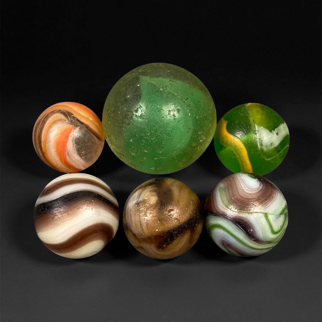 Vintage Glass Marbles Lot, Mid-20th Century, 1.5-2.3cm: This charming lot of vintage glass marbles, dating from the mid-20th century, reflects the artistry and playfulness of early handmade and molded glass craftsmanship. These marbles were produced during