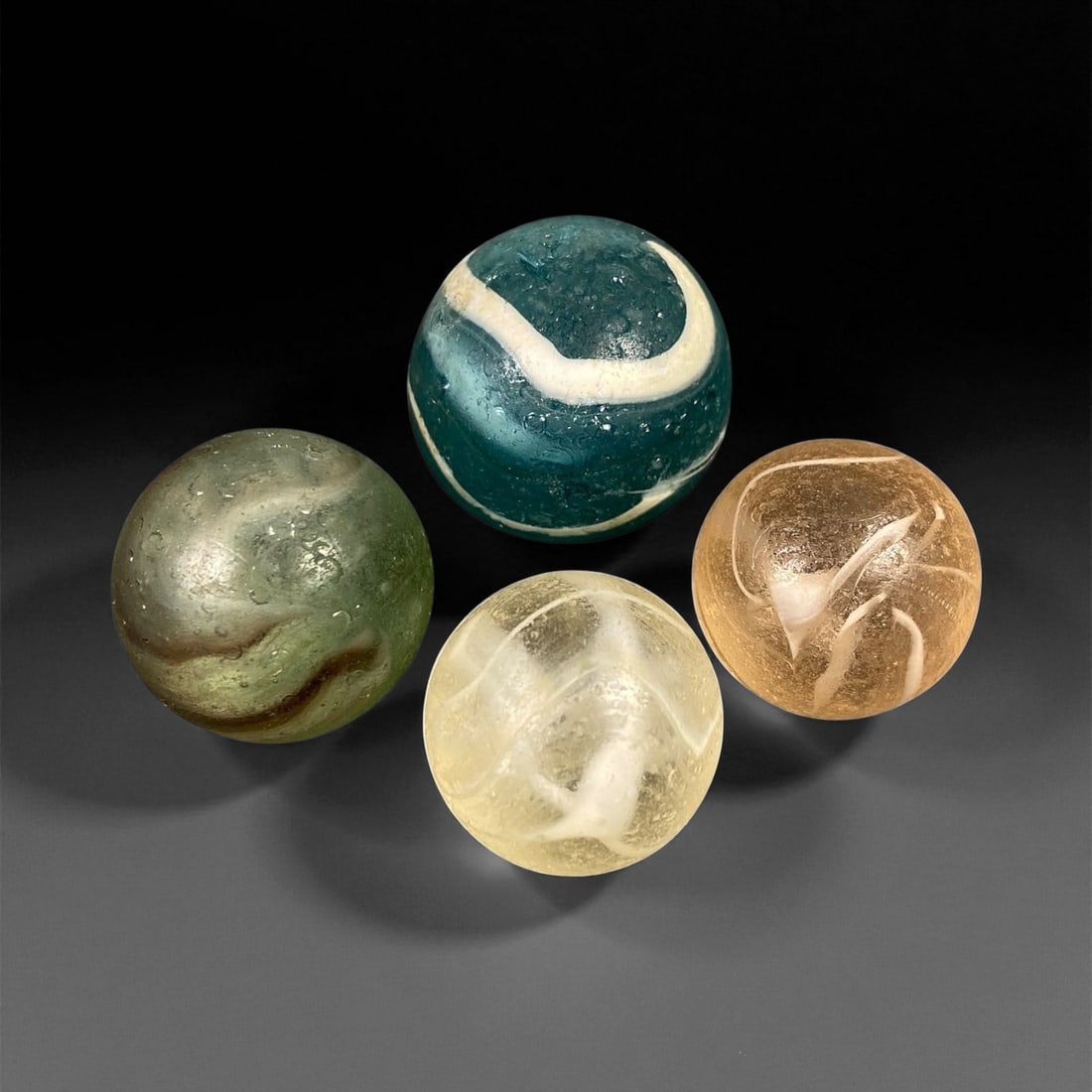 Vintage Glass Marbles Lot, Mid-20th Century, 2.1-2.7cm: This charming lot of vintage glass marbles, dating from the mid-20th century, reflects the artistry and playfulness of early handmade and molded glass craftsmanship. These marbles were produced during