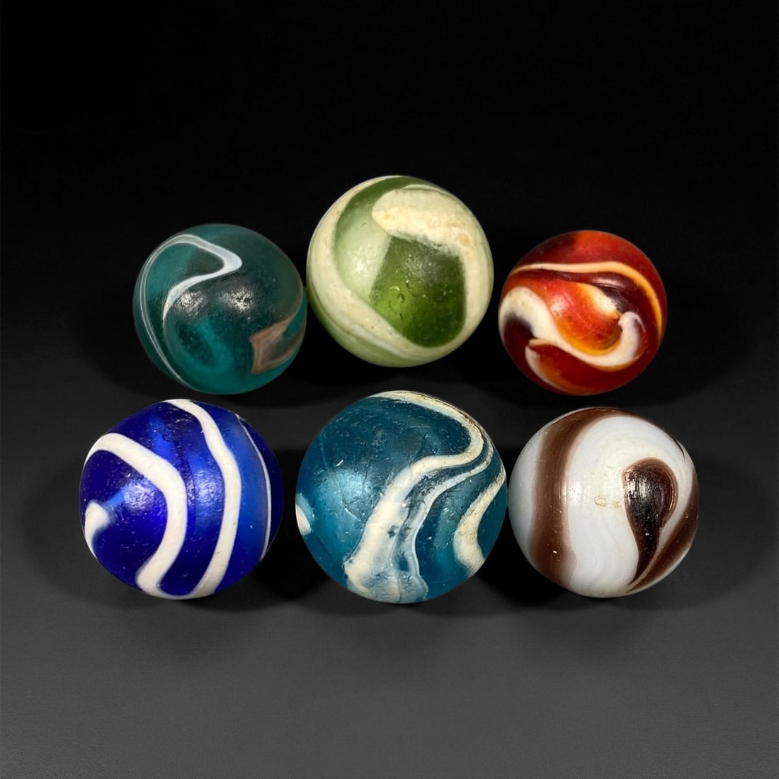 Vintage Glass Marbles Lot, Mid-20th Century, 1.5-1.7cm: This charming lot of vintage glass marbles, dating from the mid-20th century, reflects the artistry and playfulness of early handmade and molded glass craftsmanship. These marbles were produced during