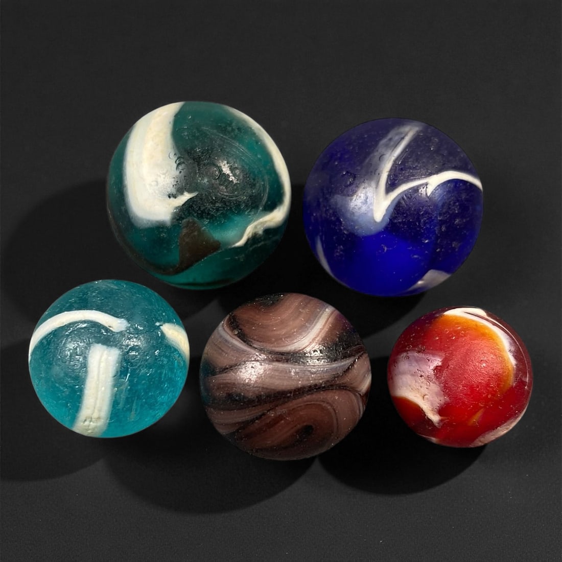 Vintage Glass Marbles Lot, Mid-20th Century, 1.5-2.2cm: This charming lot of vintage glass marbles, dating from the mid-20th century, reflects the artistry and playfulness of early handmade and molded glass craftsmanship. These marbles were produced during