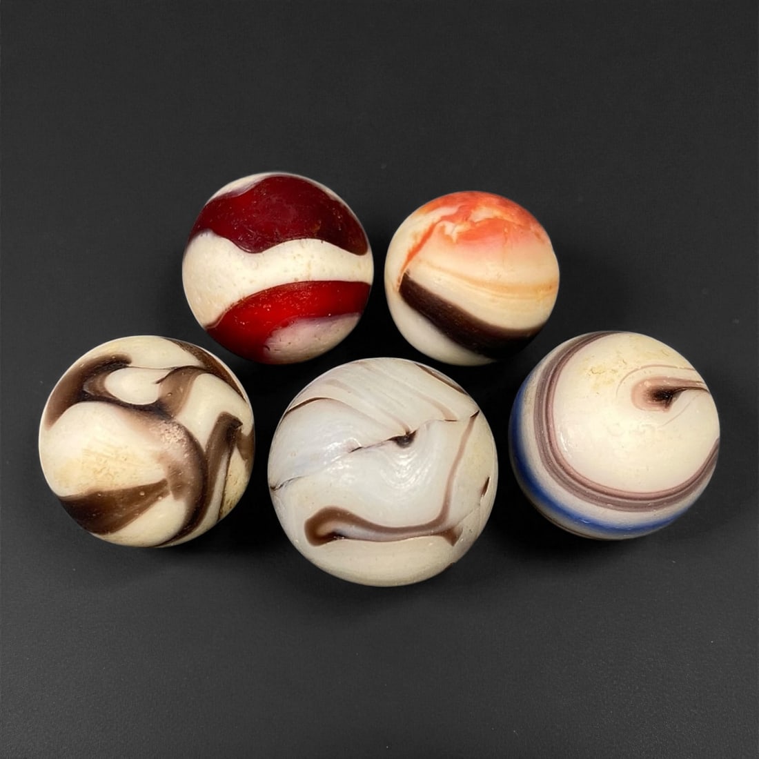 Vintage Glass Marbles Lot, Mid-20th Century, 1.4-1.7cm: This charming lot of vintage glass marbles, dating from the mid-20th century, reflects the artistry and playfulness of early handmade and molded glass craftsmanship. These marbles were produced during