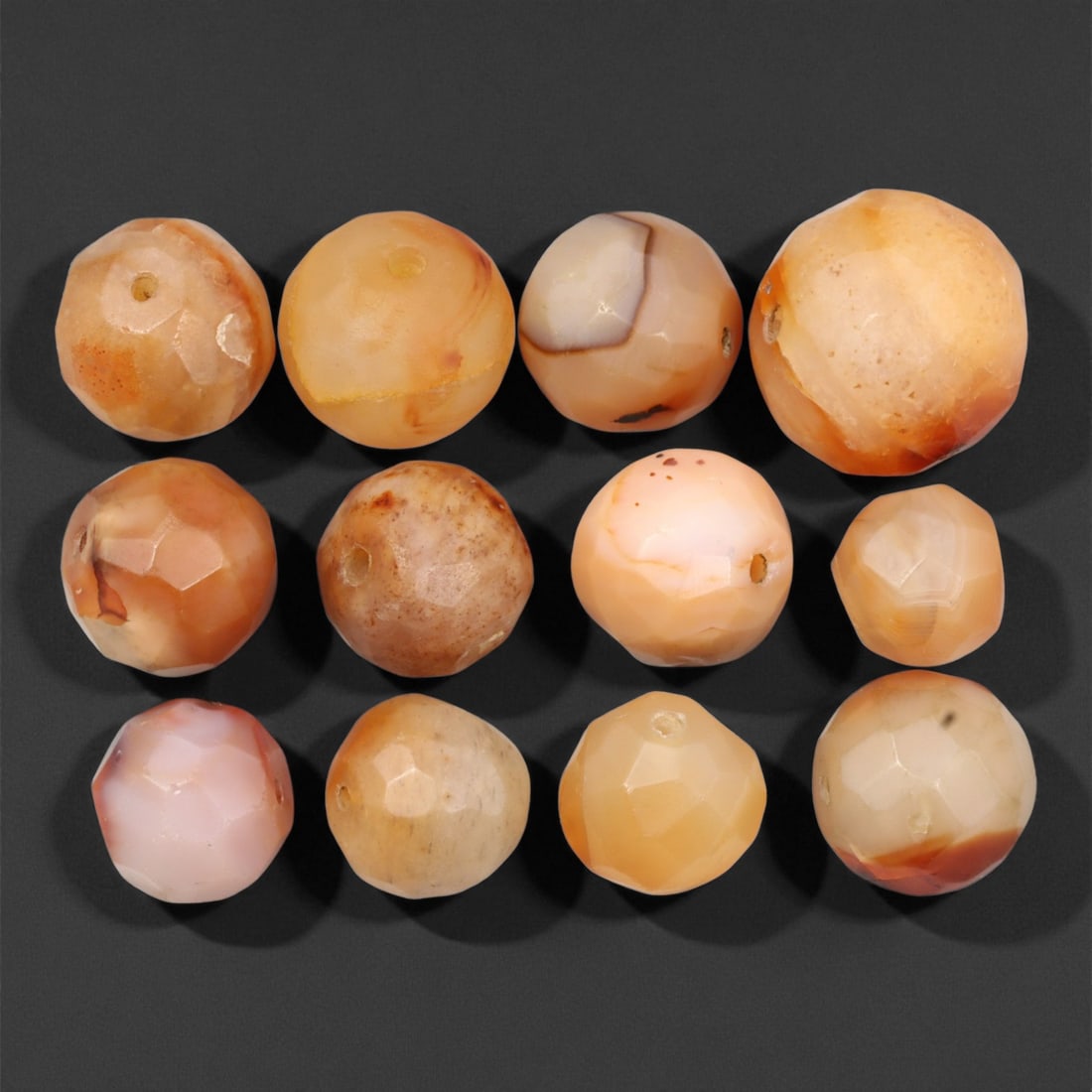 Antique Indo-Tibetan Faceted Carnelian Beads, c. 18th-19th Century, 1.2-1.9cm: This fine lot of twelve antique faceted carnelian beads originates from the Indo-Tibetan trade routes of the 18th-19th century. Each bead is carefully hand-cut and polished into soft geometric facets,