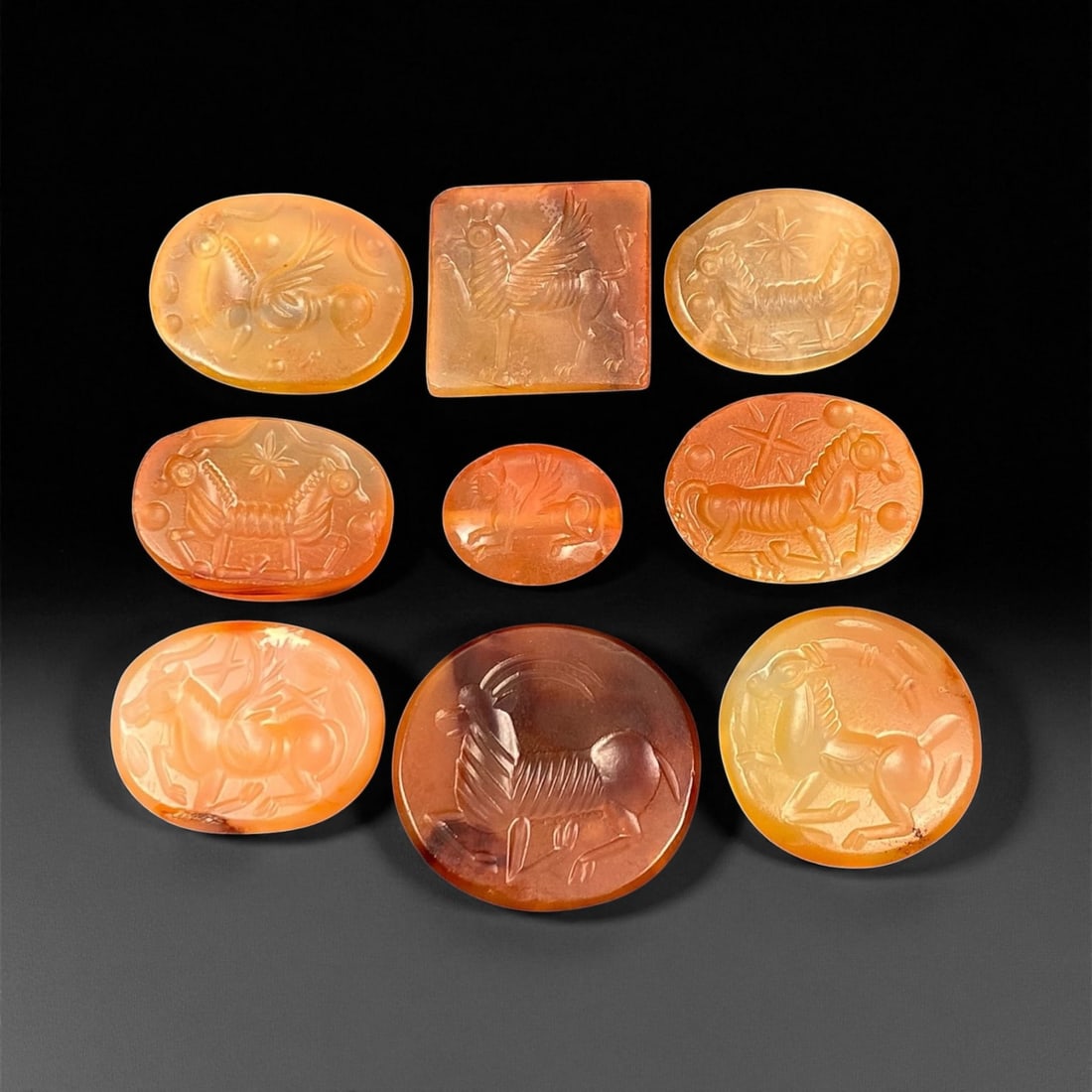 Ancient Sasanian Carnelian Mythic Creatures Intaglio Seals, c. 3rd-6th Century CE, 1.3-2.2cm: This refined group of ancient Sasanian carnelian intaglio seals dates from the 3rd-6th century CE, during the height of the Sasanian Empire. Each gem is delicately carved with stylized depictions of a