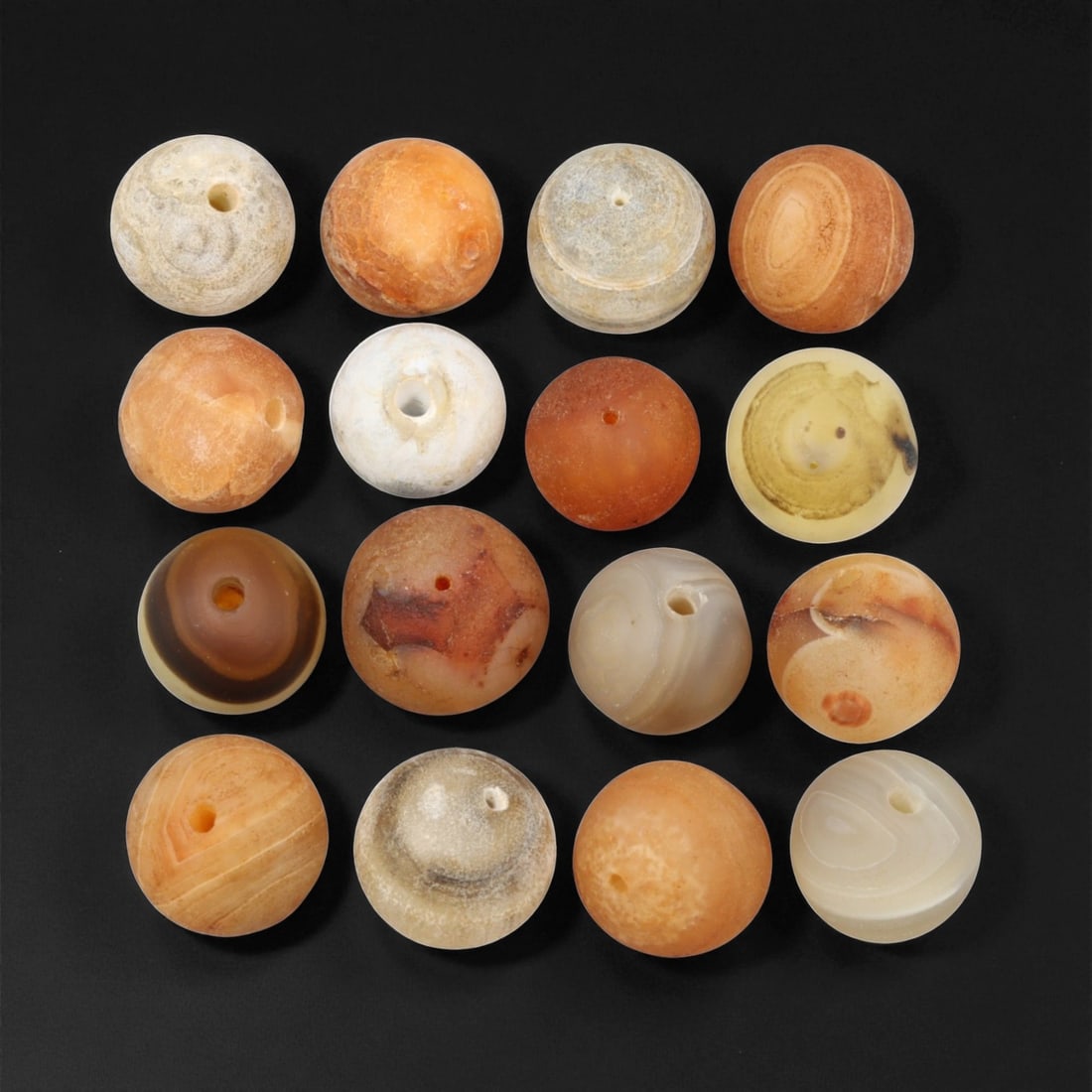 Antique Tibetan Carnelian and Agate Beads, c. 18th-19th Century, 1-1.4cm: This fine group of antique Tibetan beads, carved from carnelian and agate, dates to the 18th-19th century. Each spherical bead displays unique natural banding and earthy translucence, ranging in color
