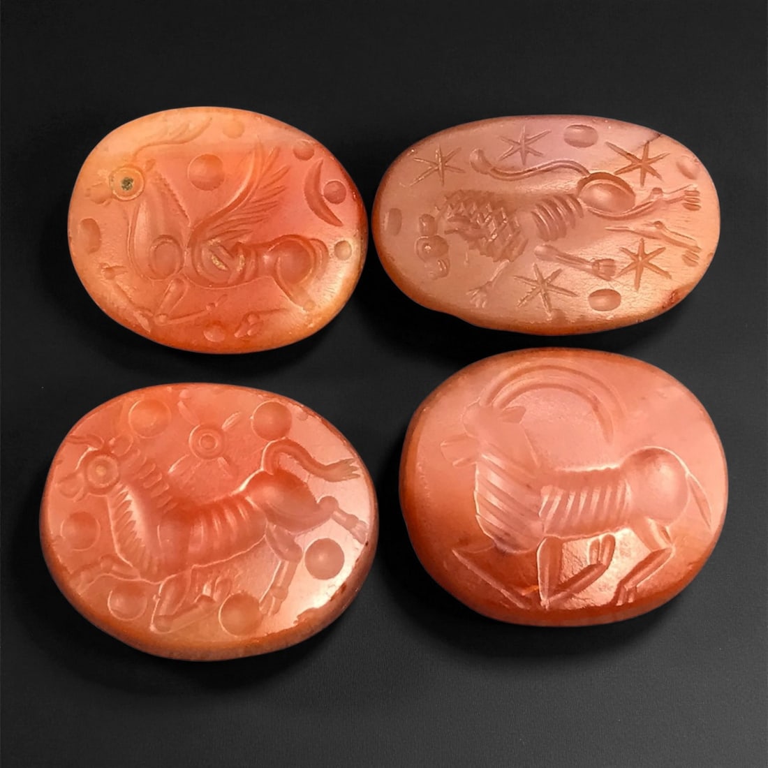 Ancient Sasanian Carnelian Mythic Creatures Intaglio Seals, c. 3rd-6th Century CE, 2-2.3cm: This refined group of ancient Sasanian carnelian intaglio seals dates from the 3rd-6th century CE, during the height of the Sasanian Empire. Each gem is delicately carved with stylized depictions of a