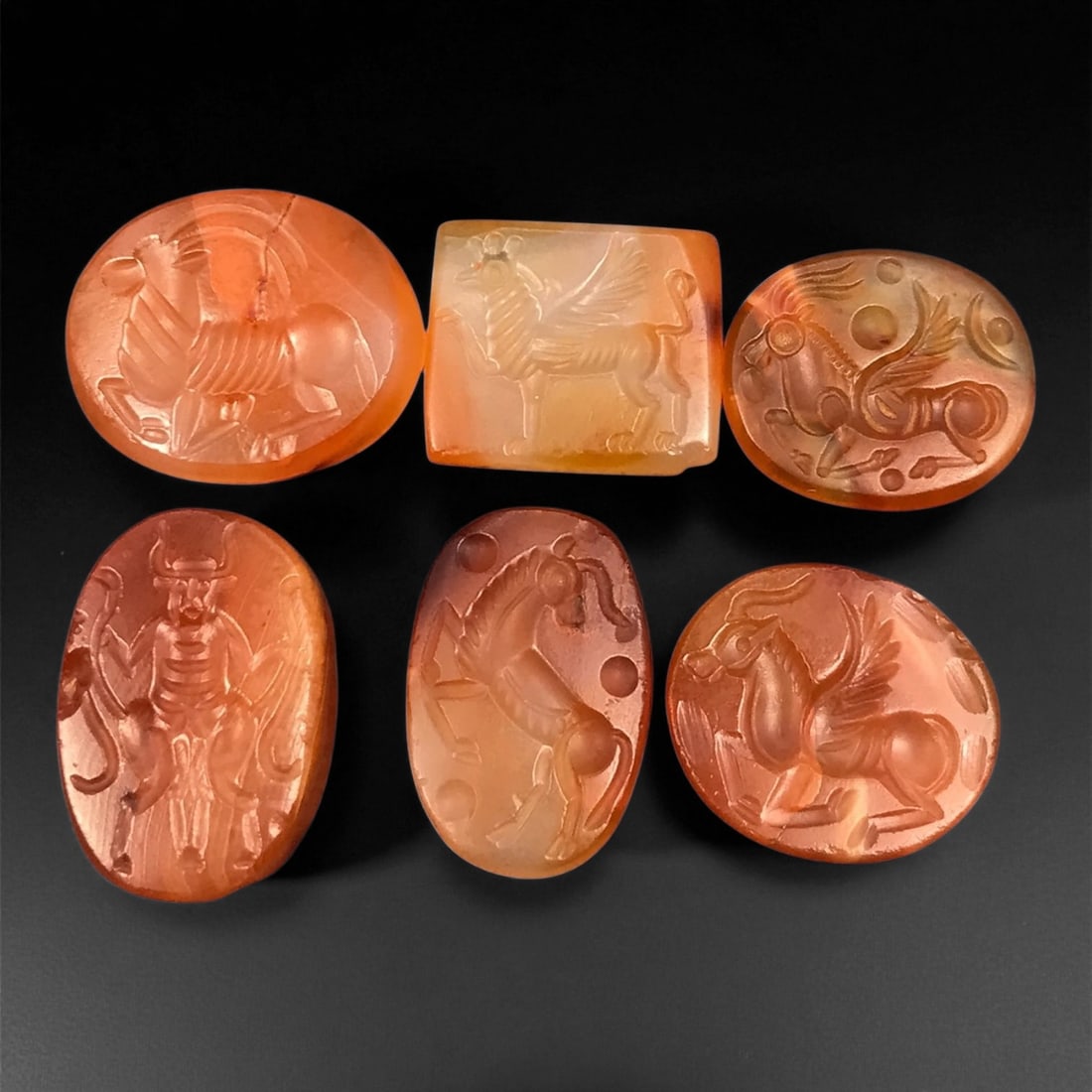 Ancient Sasanian Carnelian Mythic Creatures Intaglio Seals, c. 3rd-6th Century CE, 1.8-2.1cm: This refined group of ancient Sasanian carnelian intaglio seals dates from the 3rd-6th century CE, during the height of the Sasanian Empire. Each gem is delicately carved with stylized depictions of a