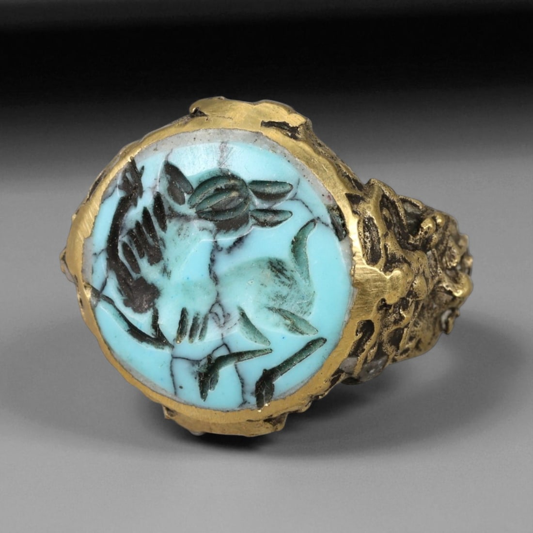 Antique Qajar Gold Gilt Intaglio Signet Ring, c. 19th-20th Century, 6.5 US: This substantial gilt ring, dating to the Qajar era of the 19th-20th century, embodies the regal aesthetic and cultural refinement of Persian jewelry traditions. The bezel is set with an engraved inta