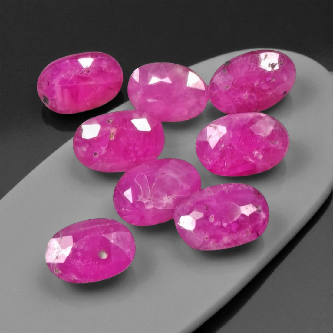 6.40 Carats Vivid Pinkish Red Ruby Oval Lot - Natural Mozambique Stones: This lively lot of ruby ovals glows with an intense pinkish-red tone that captures the eye with warmth and vibrancy. Each gem, measuring approximately 5.9x3.9x3.5mm, reveals a balance of medium to dee