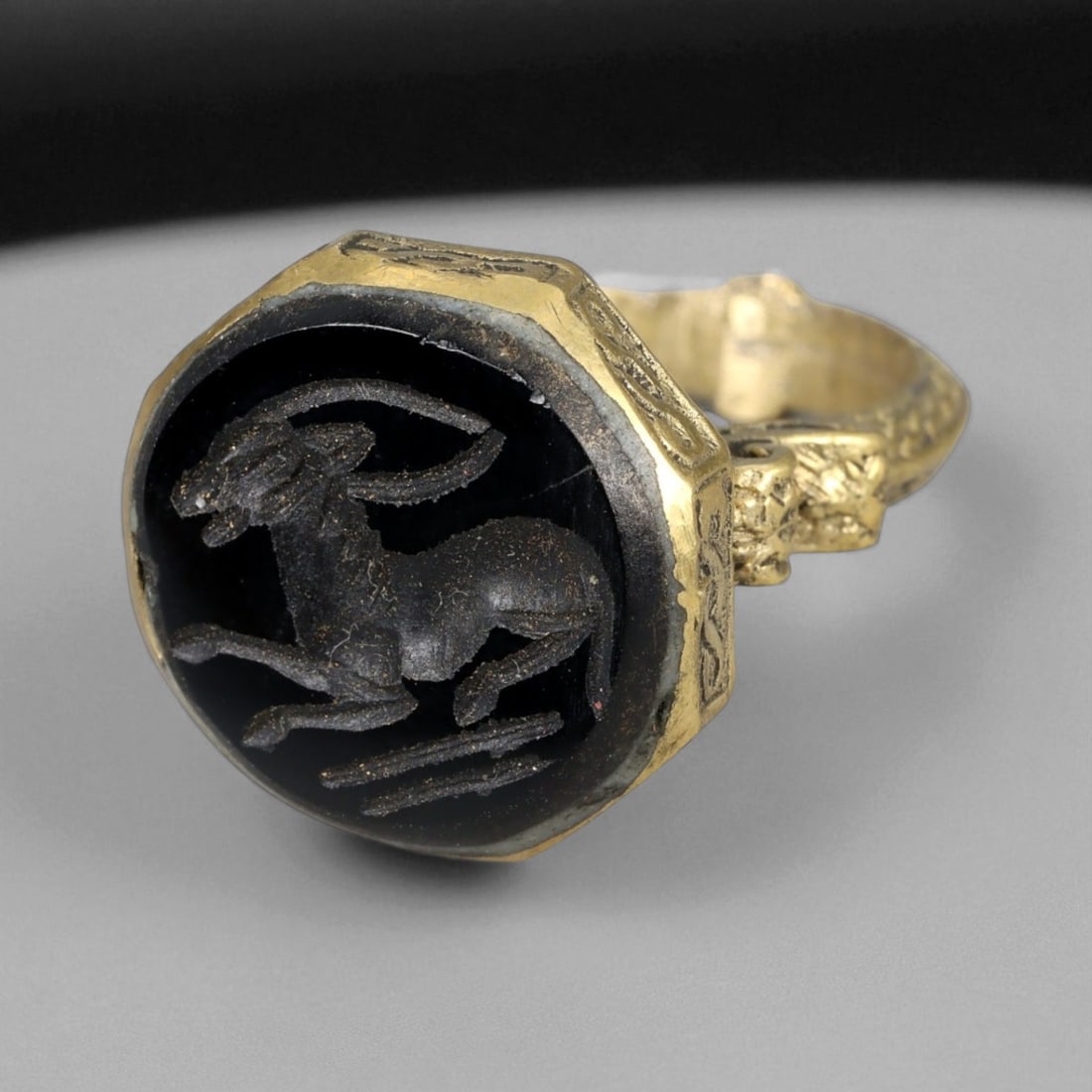 Antique Qajar Gold Gilt Intaglio Signet Ring, c. 19th-20th Century, 8 US: This substantial gilt ring, dating to the Qajar era of the 19th-20th century, embodies the regal aesthetic and cultural refinement of Persian jewelry traditions. The bezel is set with an engraved inta