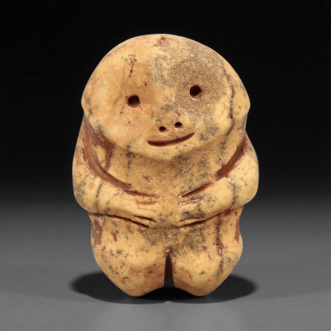 Ancient Medieval Coptic Egyptian Stone Figurine Amulet, c. 6th-9th Century CE, 4cm: This charming and serene stone figurine amulet, carved from warm beige stone with natural reddish veining, dates to the Coptic Egyptian period between the 6th and 9th centuries CE. Depicting a stylize