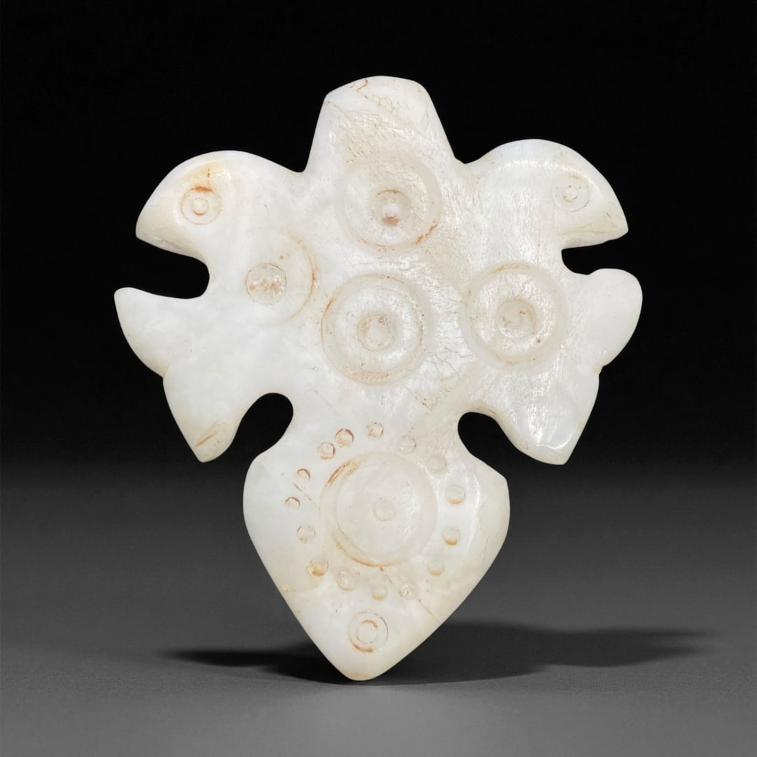 Ancient Persian Chalcedony-Jade Amulet with Solar Motifs, c. 800-500 BCE 8cm 70g: This striking ancient amulet, carved from translucent white chalcedony-jade and weighing 70 grams, dates to the early Achaemenid period of ancient Persia, c. 800-500 BCE. The piece exemplifies the ref