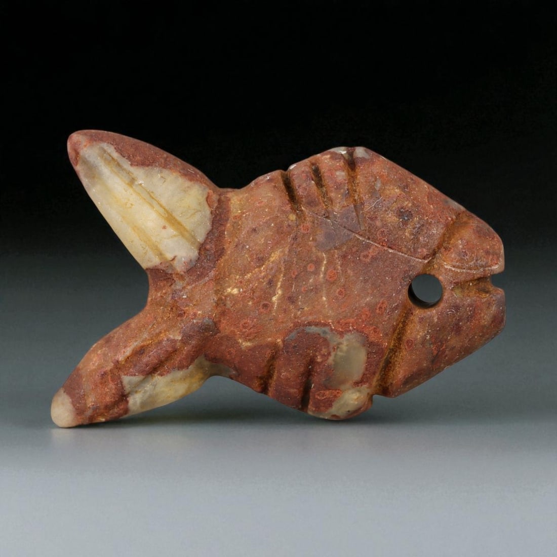 Ancient Indus Valley Red Jasper Fish Amulet, c. 2600-1900 BCE, 3cm: This finely carved red jasper amulet, depicting a stylized fish, originates from the Indus Valley Civilization, one of the earliest centers of urban and artistic achievement in human history (c. 2600-