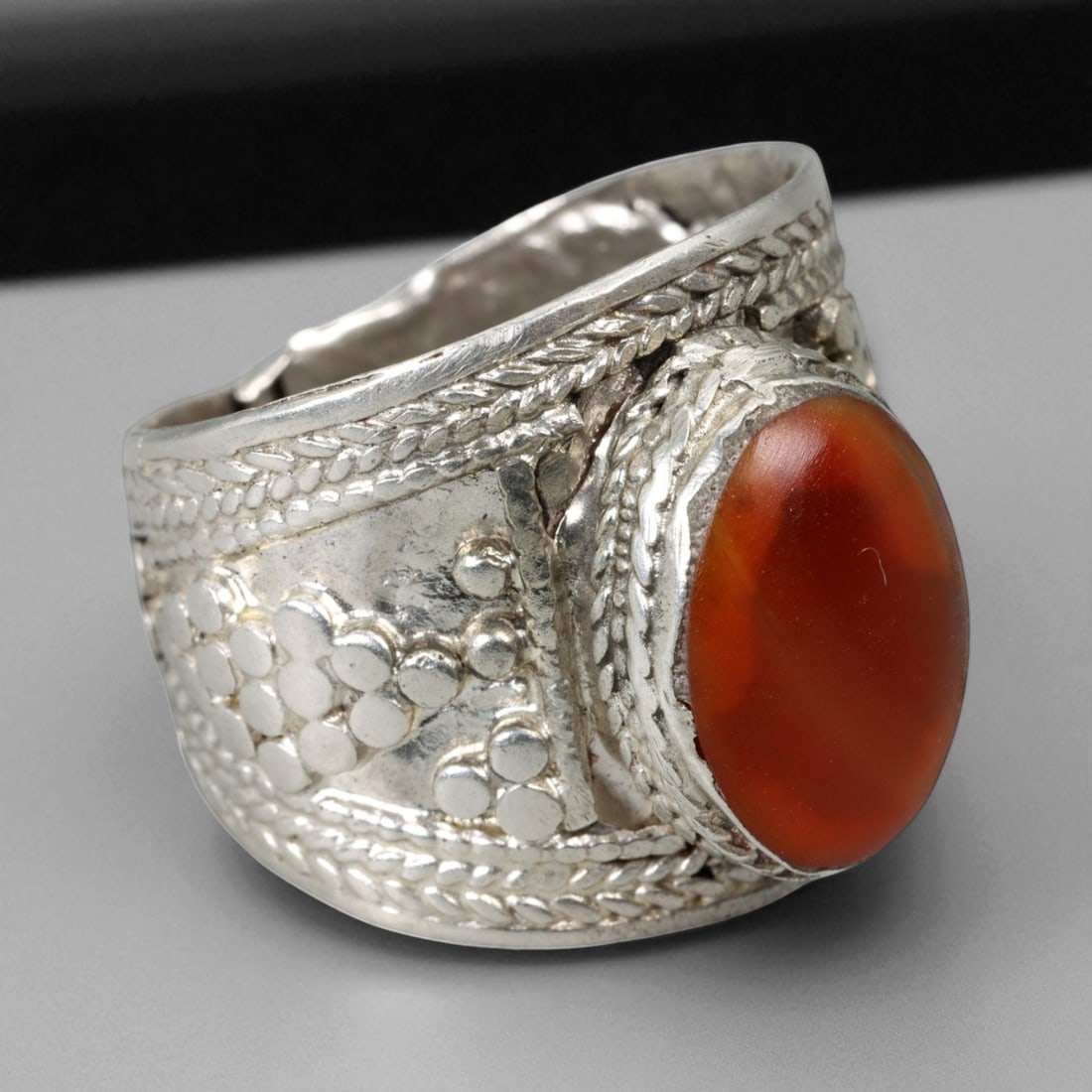 Antique Central Asian Tribal Carnelian Silver Ring, c. 19th-20th Century, US 9: This bold and finely crafted antique silver ring captures the spirit of Central Asian tribal artistry from the late 19th to early 20th century. Centered with a rich orange-red carnelian cabochon, the