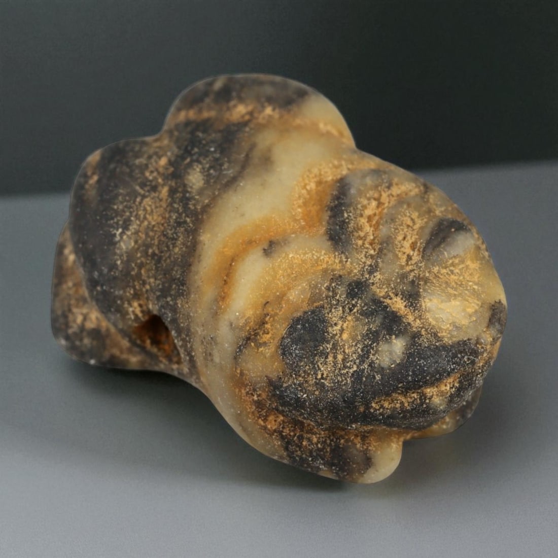 Ancient Achaemenid Persian Banded Chalcedony Frog Amulet, c. 5th-4th Century BCE (2 cm): This delicately carved frog amulet, sculpted from banded chalcedony with striking natural tones of black, cream, and honey, originates from the Achaemenid Persian Empire. Compact yet graceful, the for