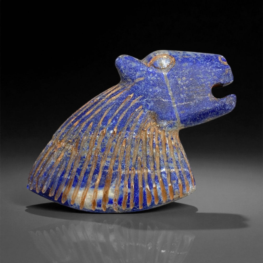 Ancient Bactrian Lapis Lazuli Lion-Head Plaque, c. 2nd-1st Millennium BCE, 6cm, 60g: This magnificent lapis lazuli plaque, carved in the form of a roaring lion's head, originates from ancient Bactria, circa 2nd-1st millennium BCE. Bold yet refined, the plaque exemplifies the distincti