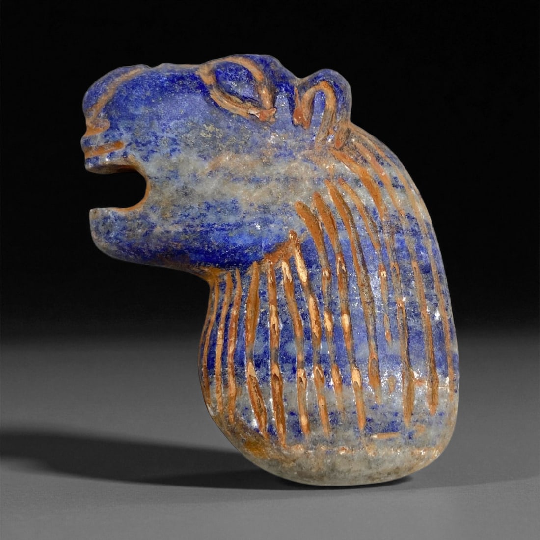 Ancient Bactrian Lapis Lazuli Lion-Head Plaque, c. 2nd-1st Millennium BCE, 5cm, 54g: This magnificent lapis lazuli plaque, carved in the form of a roaring lion's head, originates from ancient Bactria, circa 2nd-1st millennium BCE. Bold yet refined, the plaque exemplifies the distincti