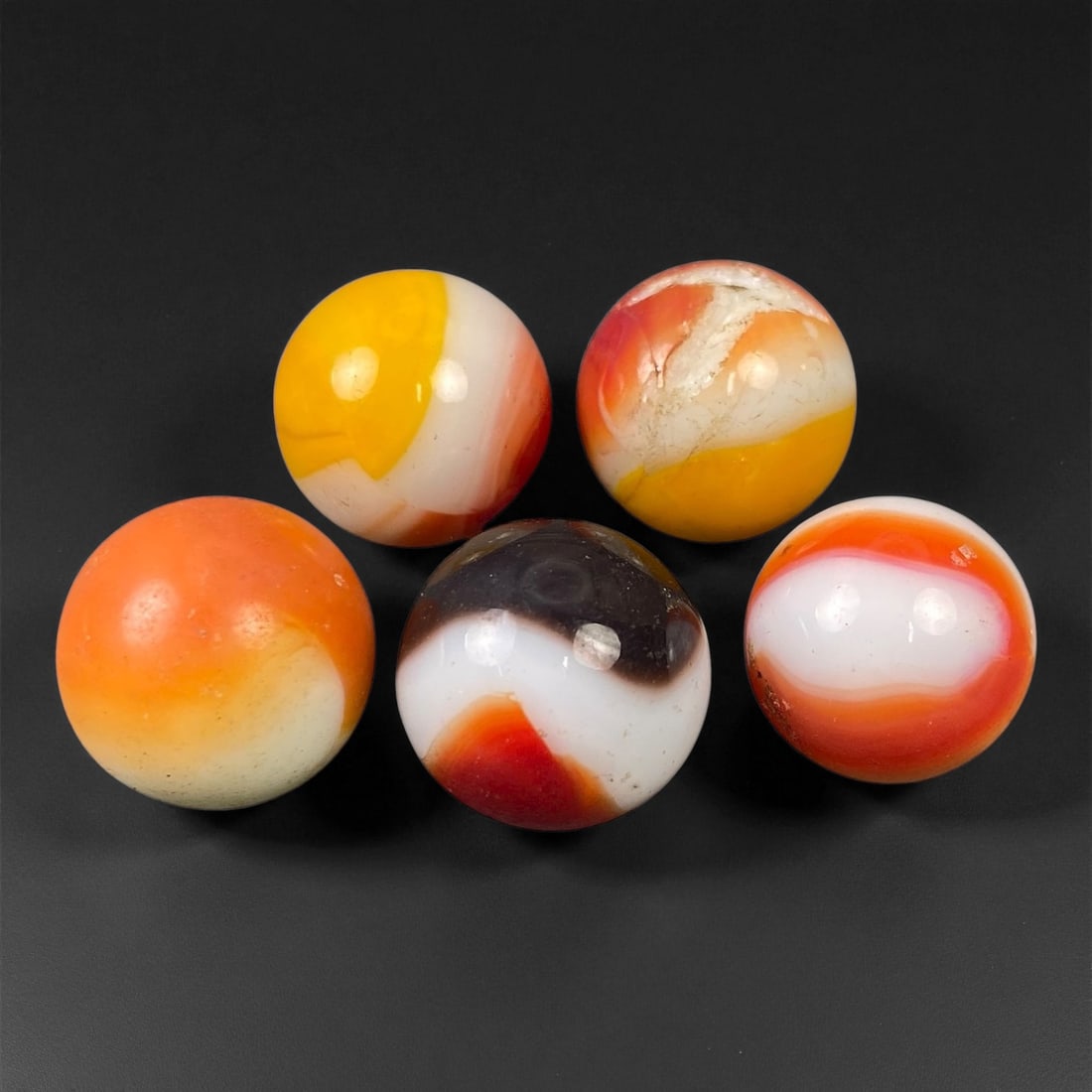 Vintage Glass Marbles Lot, Mid-20th Century, 1.4-1.6cm: This charming lot of vintage glass marbles, dating from the mid-20th century, reflects the artistry and playfulness of early handmade and molded glass craftsmanship. These marbles were produced during