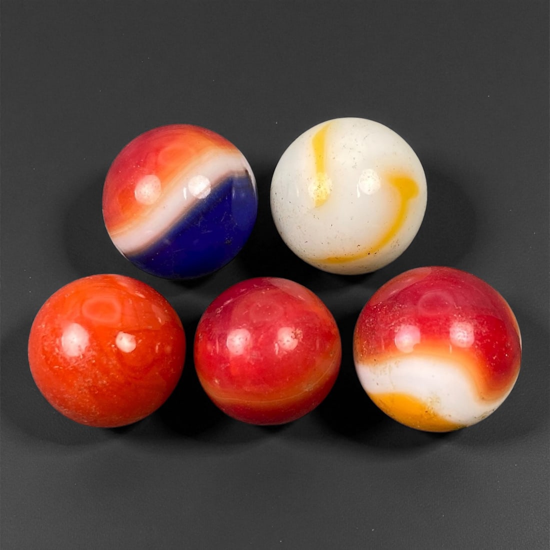 Vintage Glass Marbles Lot, Mid-20th Century, 1.4-1.6cm: This charming lot of vintage glass marbles, dating from the mid-20th century, reflects the artistry and playfulness of early handmade and molded glass craftsmanship. These marbles were produced during