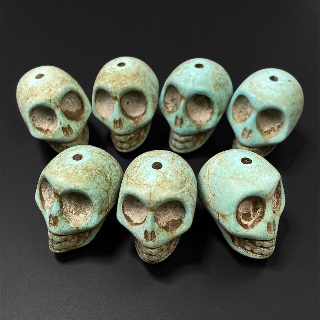 Vintage Tibetan Turquoise Skull Beads, c. Mid-20th Century, 1.7cm: This striking set of turquoise-carved skull beads, originates from Tibet and dates to the mid-20th century. Finely shaped and perforated for stringing, each bead represents a human skull, a motif rich