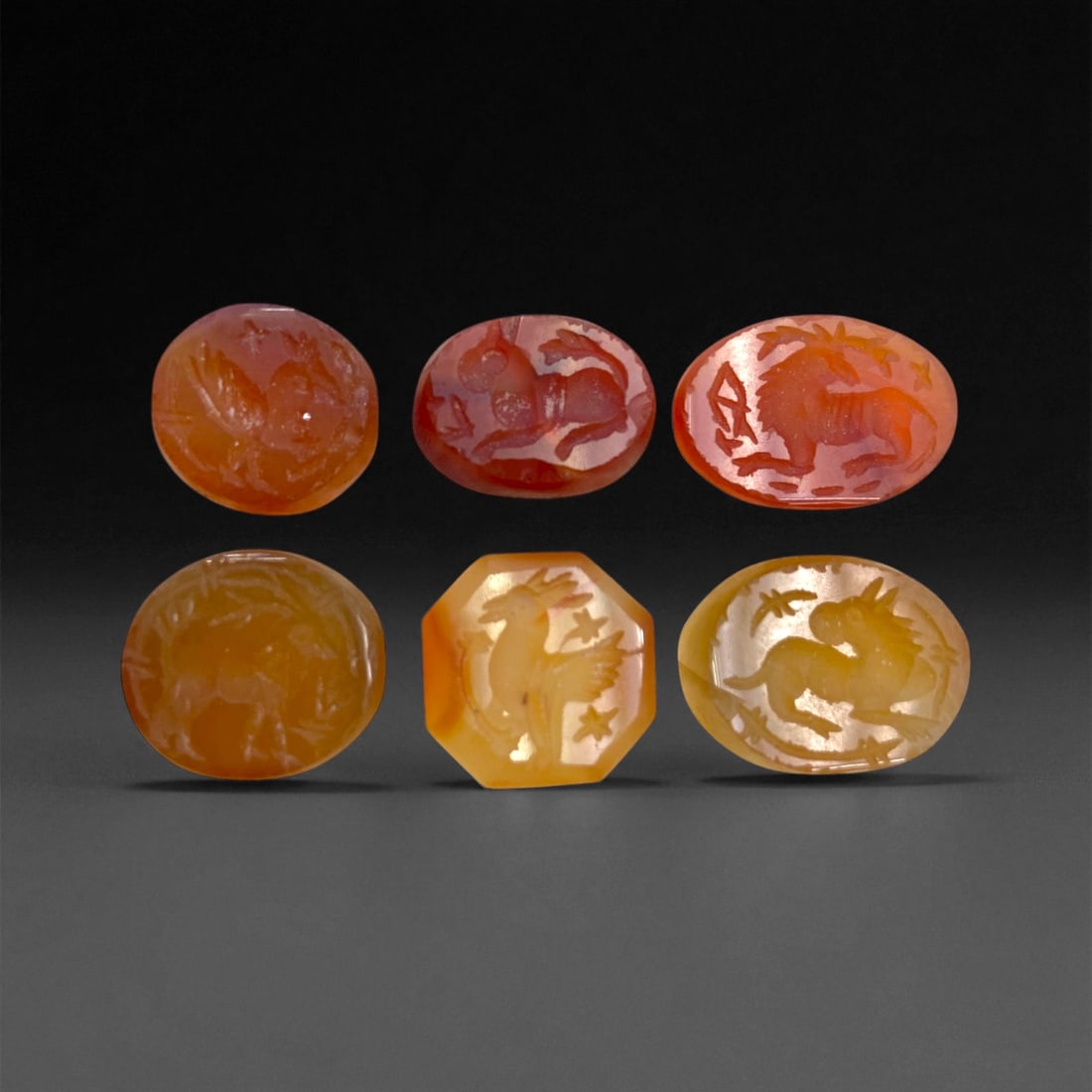 Ancient Sasanian Carnelian and Chalcedony Intaglio Group, c. 3rd-6th Century CE, 1.5cm, 13g: This remarkable set of six engraved Sasanian intaglios embodies the intricate artistry and cosmological symbolism of imperial Persia's golden age. Each stone, carved in carnelian and honey chalcedony,