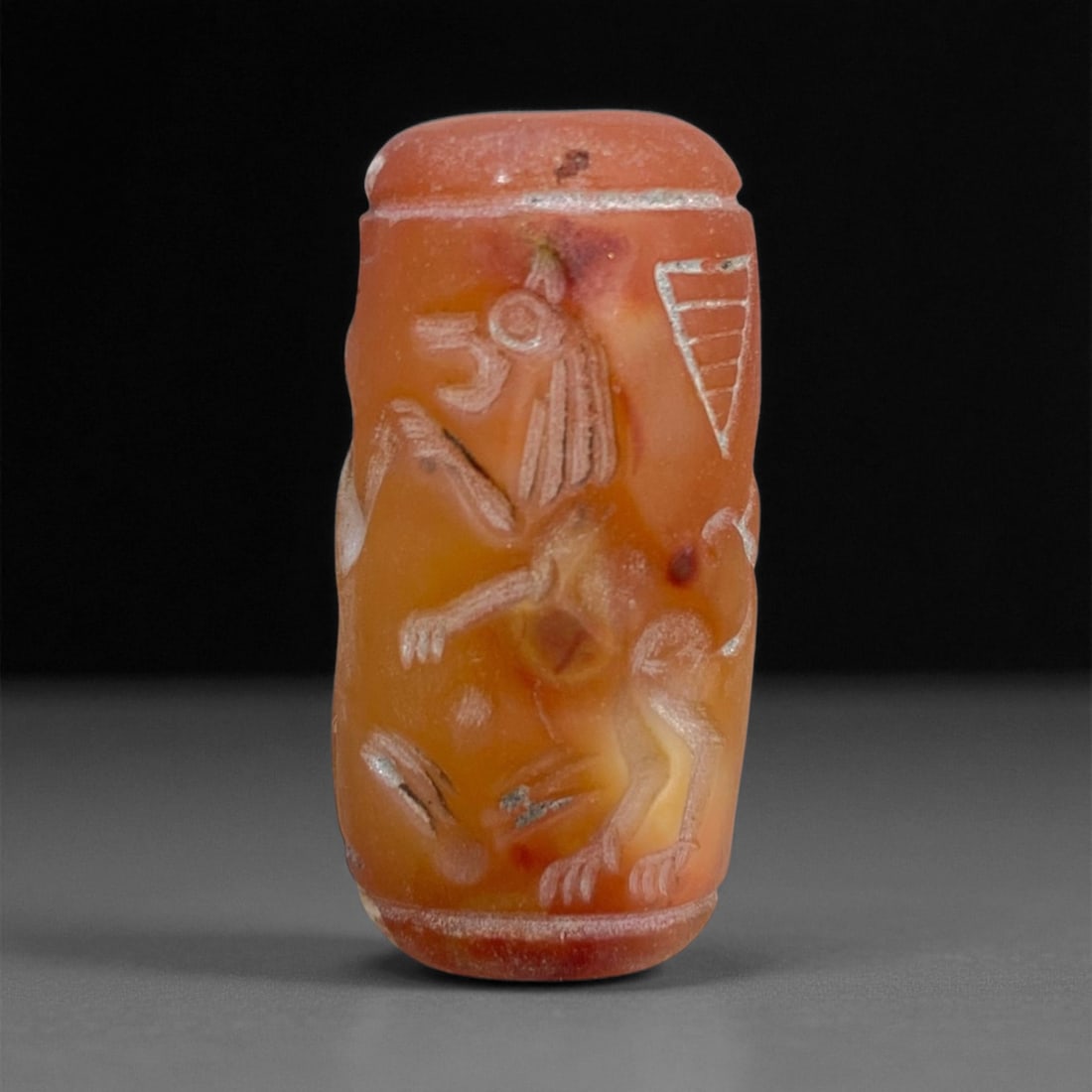 Ancient Akkadian Winged Deity Carnelian Cylinder Seal, c. 2334-2154 BCE, 3cm, 10g: This remarkable carnelian cylinder seal originates from the Akkadian Empire, one of Mesopotamia's most influential civilizations (c. 2334-2154 BCE). Carved from rich orange-red carnelian, it depicts a