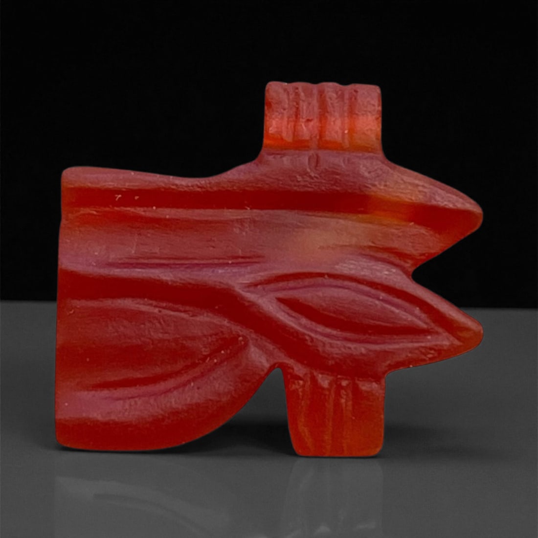 Ancient Egyptian Carnelian Wedjat Eye Amulet, c. Late Period, 7th-4th Century BCE, 1.5cm, 1g: This delicate carnelian amulet represents the Wedjat or Eye of Horus, one of the most enduring and powerful symbols in ancient Egyptian religion. The Wedjat was believed to embody healing, protection,