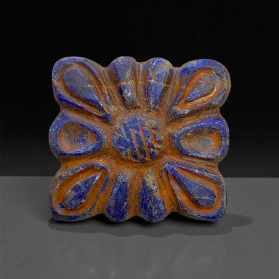Ancient Achaemenid Lapis Lazuli Floral Spacer Bead, c. 5th-4th Century BCE, 2.5cm: This finely carved floral spacer bead, is crafted from rich lapis lazuli, a prized gemstone highly valued across the ancient Near East. Its symmetrical rosette design, with radiating petal-like elemen