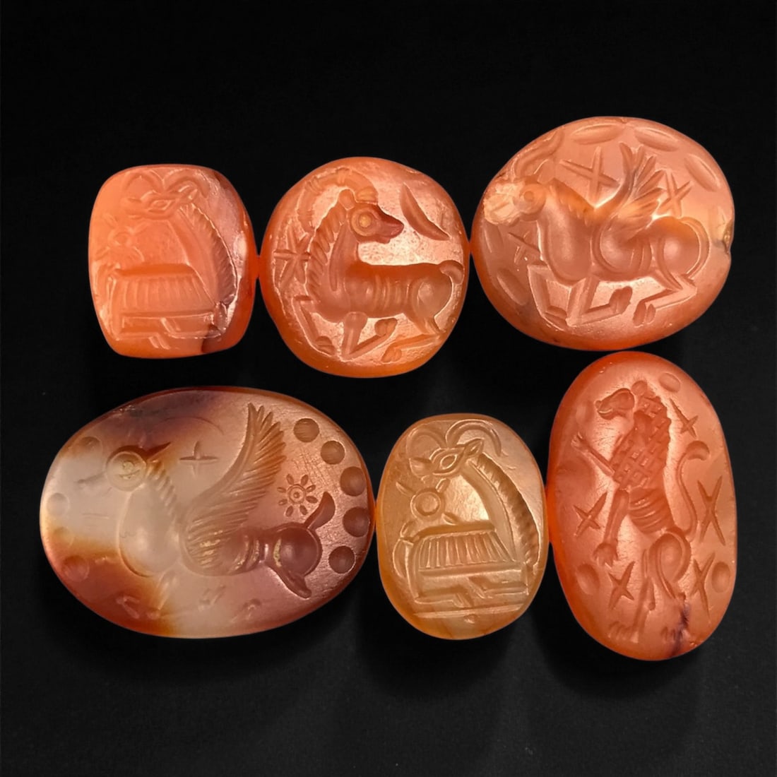 Ancient Sasanian Carnelian Mythic Creatures Intaglio Seals, c. 3rd-6th Century CE, 1.4-2.4cm: This refined group of ancient Sasanian carnelian intaglio seals dates from the 3rd-6th century CE, during the height of the Sasanian Empire. Each gem is delicately carved with stylized depictions of a