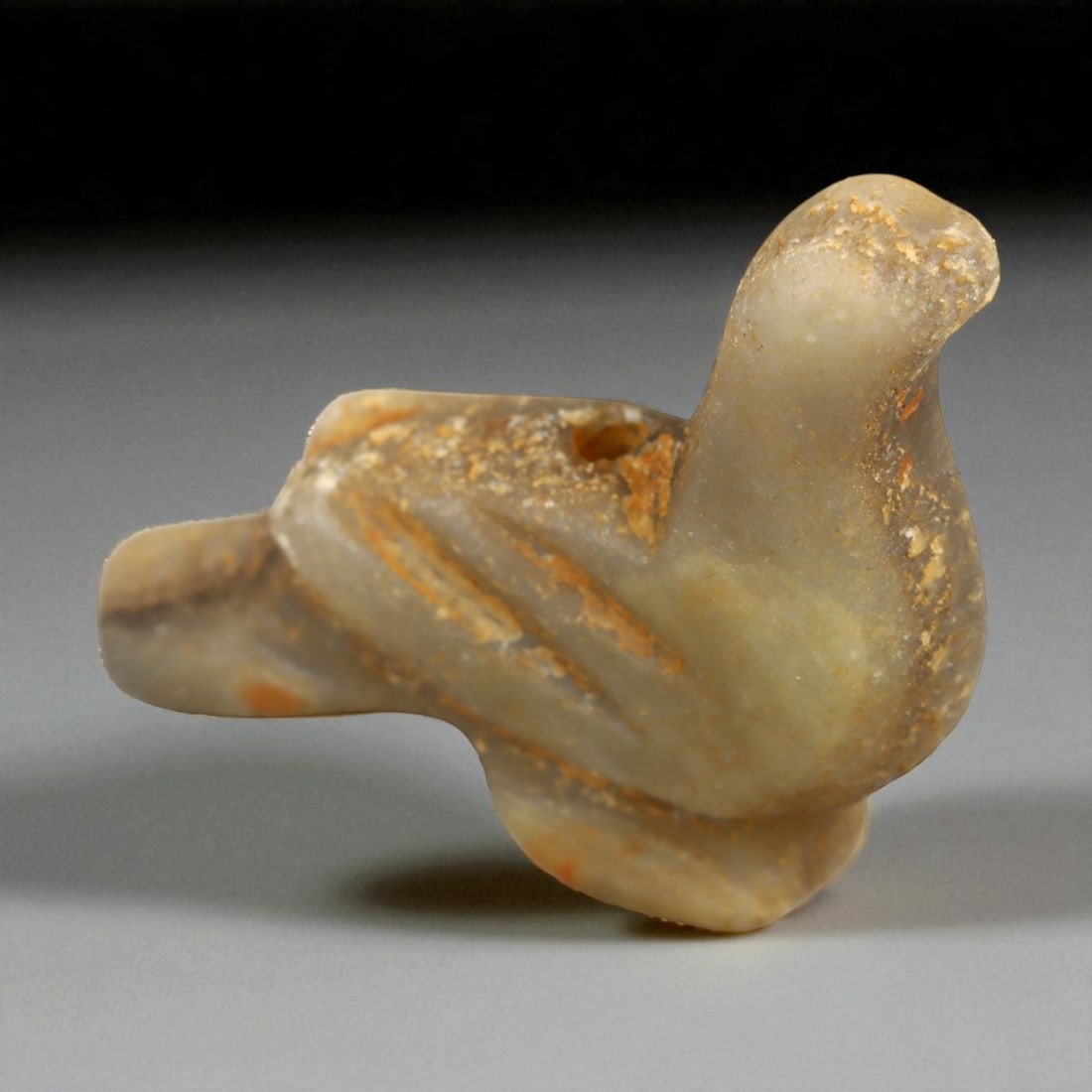 Ancient Achaemenid Persian Alabaster Bird Amulet, c. 6th-4th Century BCE (3.7 cm): This graceful bird amulet, carved from soft gray alabaster with pale ochre veining, originates from the Achaemenid Persian Empire, renowned for its elegant synthesis of symbolism, craftsmanship, and n