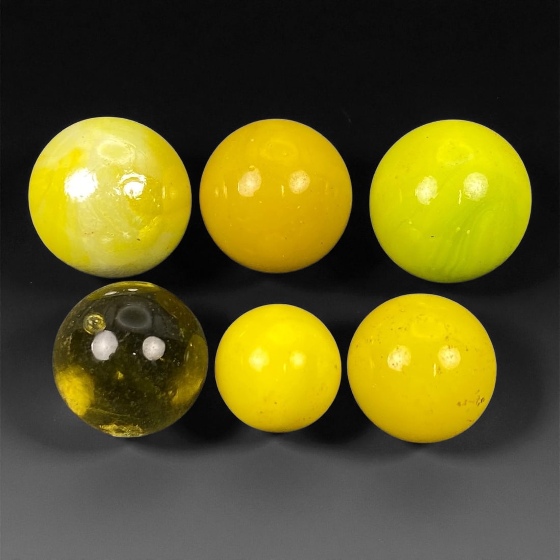 Vintage Glass Marbles Lot, Mid-20th Century, 1.2-1.6cm: This charming lot of vintage glass marbles, dating from the mid-20th century, reflects the artistry and playfulness of early handmade and molded glass craftsmanship. These marbles were produced during