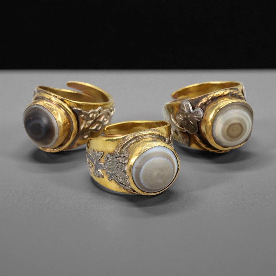 Vintage Himalayan Luk Mik Goat Eye Dzi Silver Gilt Rings Set, c. 20th Century, US 10.5-12.5: This set of vintage Himalayan Luk Mik goat eye Dzi rings reflects a long-standing tradition in the mountain regions of Tibet, Nepal, and Bhutan, where protective stones and symbolic motifs have been w