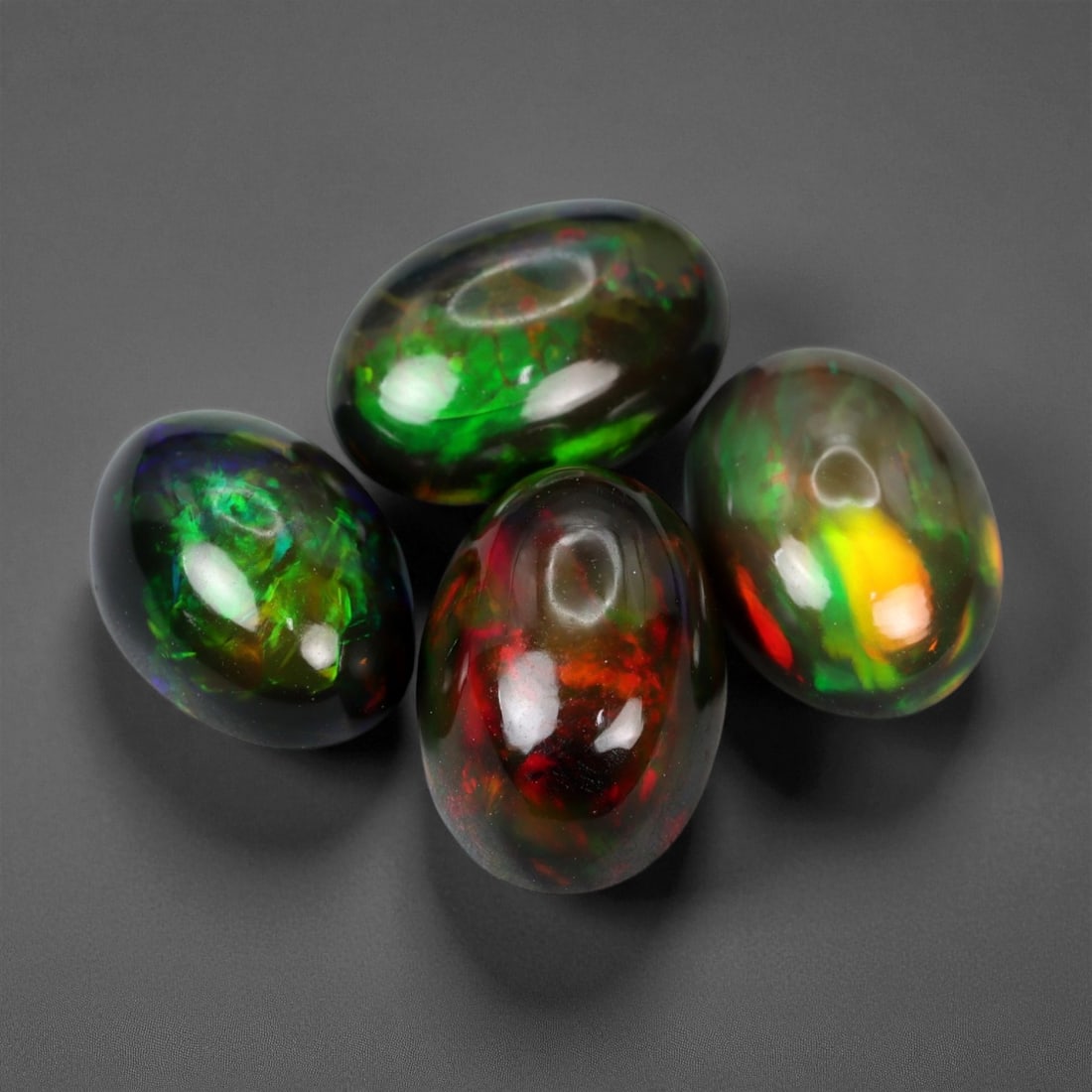 9.74 Carats Fiery Black Opal Selection - Natural Ethiopian Cabochons - 11 mm: This dramatic selection of black opals captivates with intense flashes of crimson, emerald, and molten orange, all set against deep, inky body tones that amplify their internal fire. Each stone displa