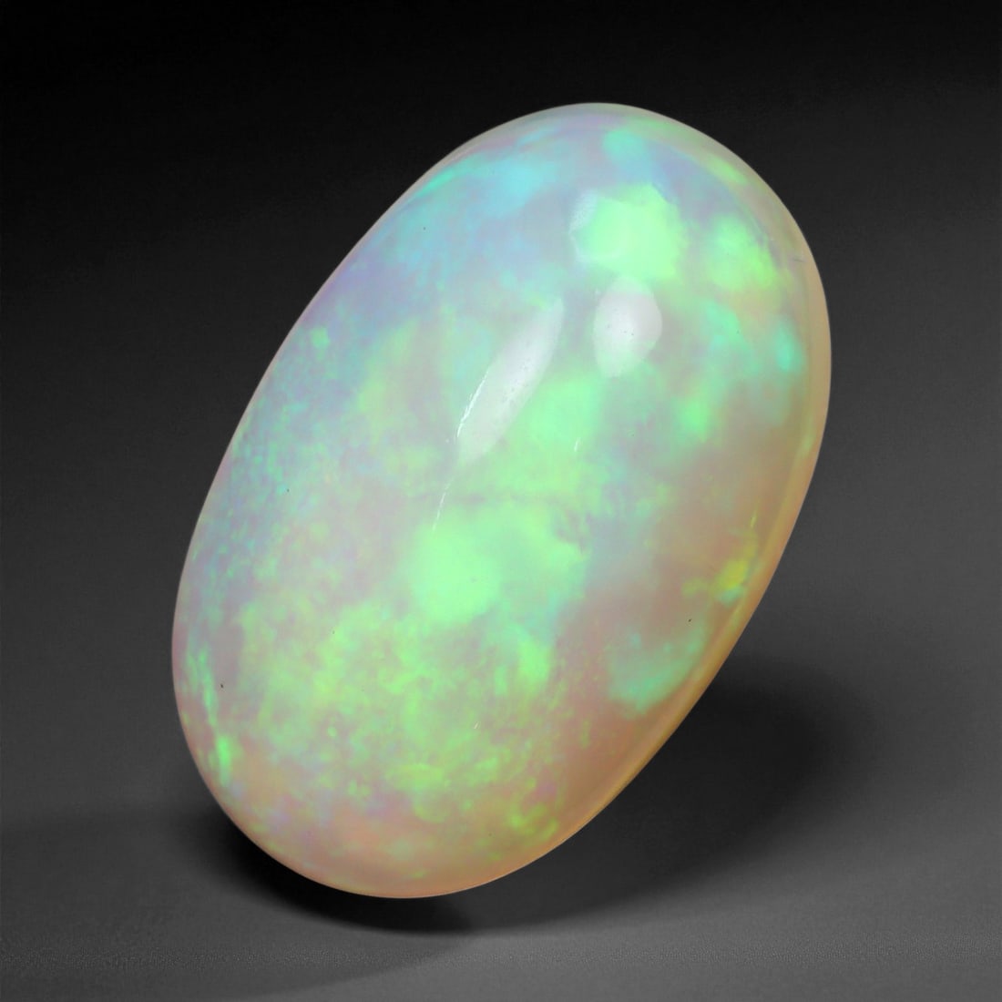 3.12 Carats Pastel Neon Welo Opal Cabochon - Natural Ethiopian Gemstone: This glowing Welo opal shimmers with delicate flashes of mint green, lavender, sky blue, and soft amber beneath a translucent, honey-toned body. Its internal light play is gentle yet vivid, with broad