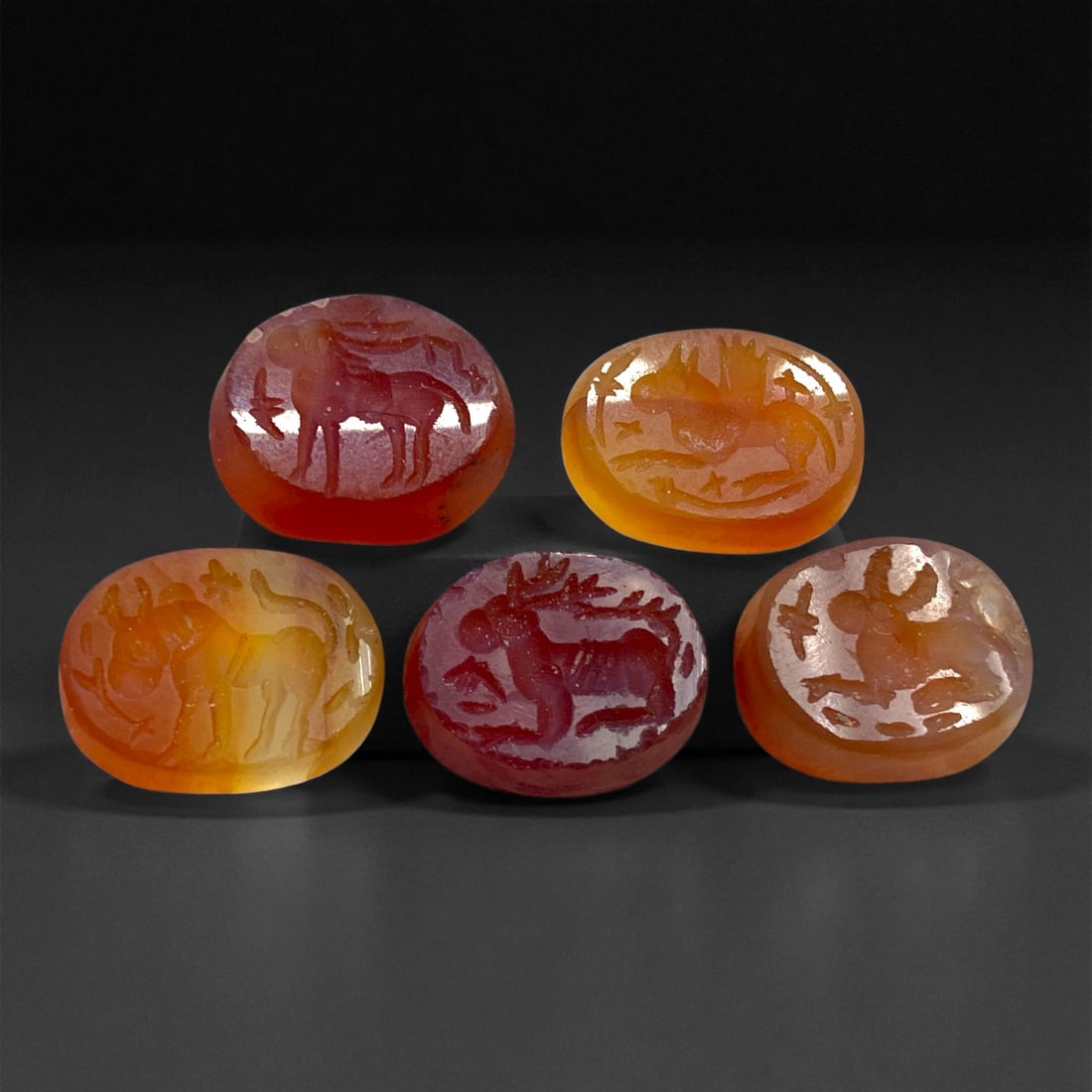Ancient Sasanian Carnelian Intaglio Seals, c. 3rd-6th Century CE, 1.5 cm, 13 g, 3DD: This fine group of five engraved carnelian intaglio seals originates from the Sasanian Empire, an era renowned for its artistic mastery and profound symbolism in hardstone carving. Each piece bears th
