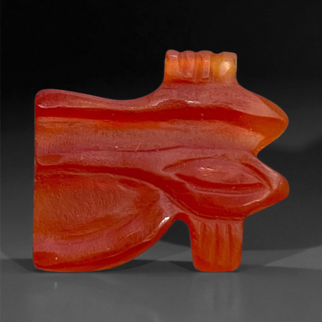 Ancient Egyptian Carnelian Wedjat Eye Amulet, c. Late Period, 7th-4th Century BCE, 1.5cm, 0.8g, 25BB: This delicate carnelian amulet represents the Wedjat or Eye of Horus, one of the most enduring and powerful symbols in ancient Egyptian religion. The Wedjat was believed to embody healing, protection,