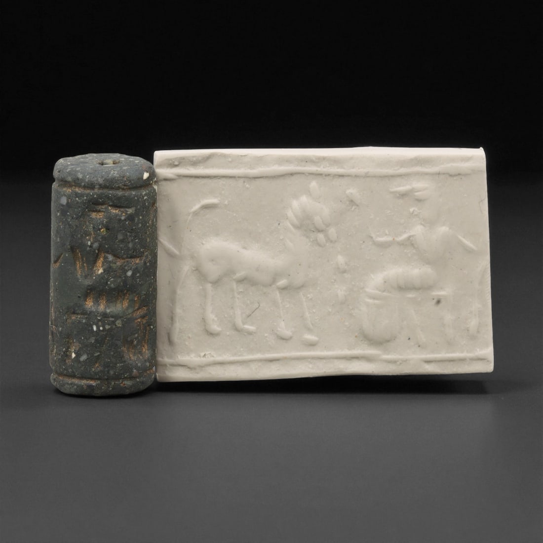 Ancient Akkadian Steatite Cylinder Seal, c. 2300-2100 BCE, 3.1cm, 91ER: Carved from fine dark steatite, this ancient Akkadian cylinder seal dates to the late 3rd millennium BCE, a period when Mesopotamian artisans perfected the art of miniature relief engraving. Each seal