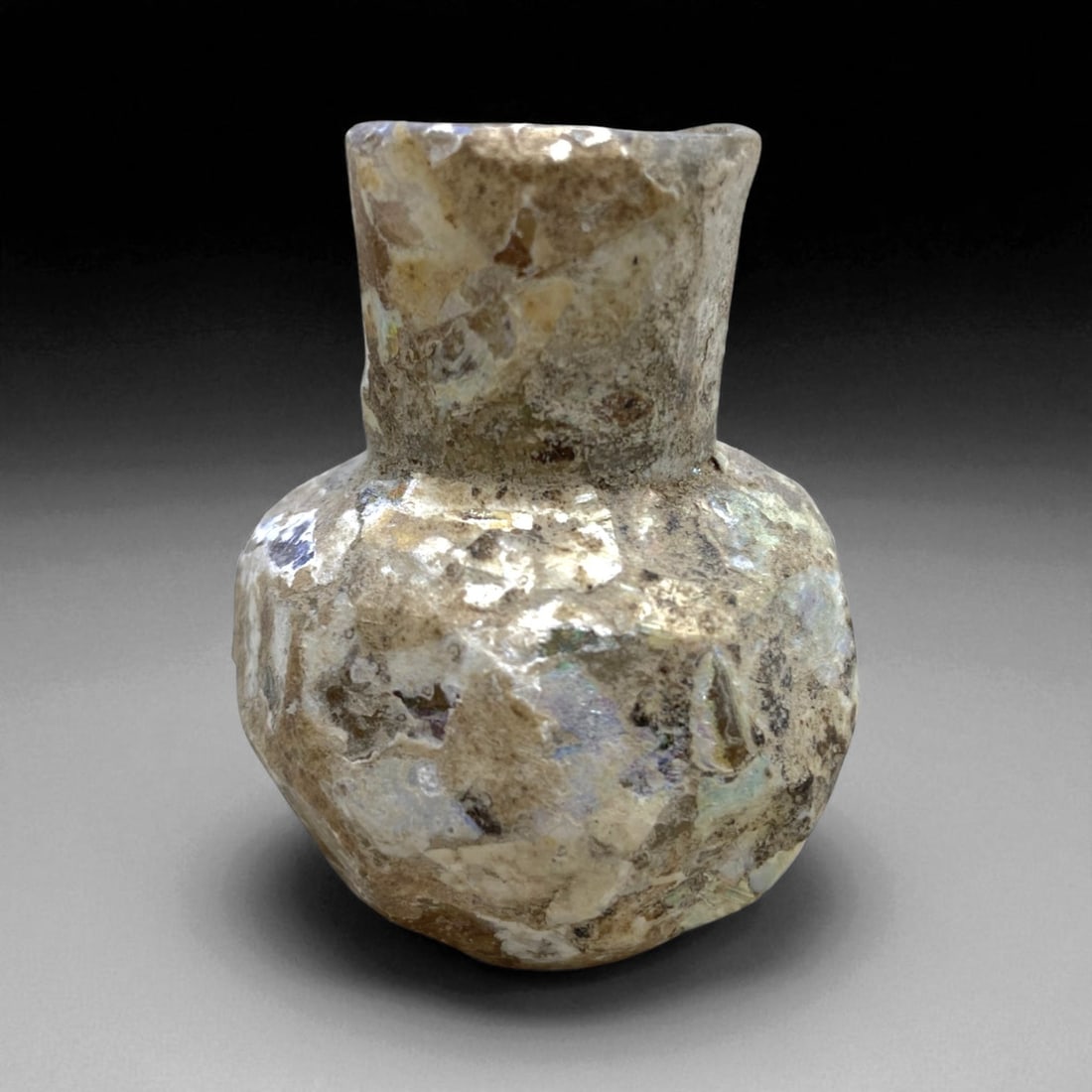 Ancient Roman Iridescent Glass Miniature Jar, c. 2nd-4th Century CE, 5cm, 26g, 25AA: This petite Roman glass jar, dating to the Imperial period (c. 2nd-4th century CE), is a remarkable example of the refined yet practical glassware that defined daily life across the Roman world. Craft