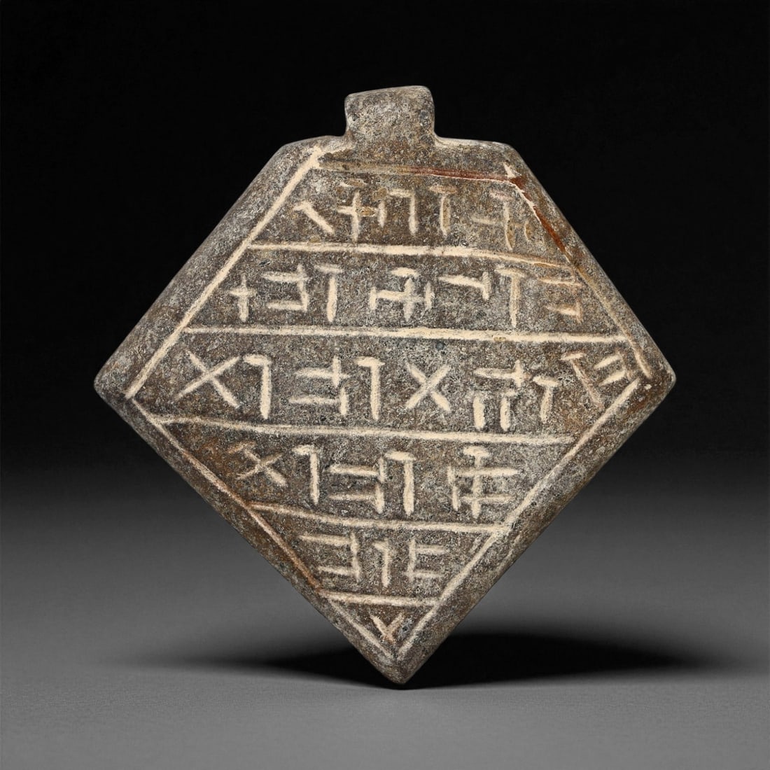 Ancient Mesopotamian Inscribed Serpentine Amulet, c. Neo-Babylonian Period, 5.9cm, 86ES: This rare serpentine amulet, engraved with neatly aligned cuneiform script, dates to the Neo-Babylonian period (circa 7th-6th century BCE). Inscribed amulets such as this held immense spiritual and pr