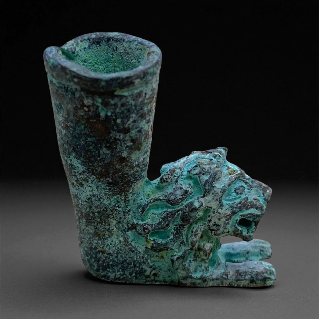 Ancient Achaemenid Bronze Lion-Head Rhyton Fragment, c. 5th-4th Century BCE, 3cm, 27g, 50BB: This miniature bronze fragment, depicting a roaring lion with a cylindrical vessel rising from its back, originates from the Achaemenid Persian Empire, circa 5th-4th century BCE. The form represents a