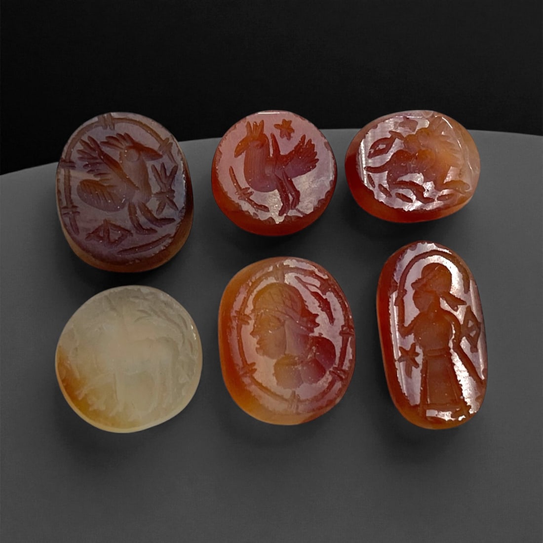 Ancient Sasanian Carnelian and Agate Intaglio Seal Lot, c. 3rd-6th Century CE 1.2-2cm 14g, 24BB: This fine assemblage of six engraved gemstones originates from the Sasanian Empire, c. 3rd-6th century CE, an era celebrated for its mastery of lapidary art and its fusion of regal, cosmic, and spirit