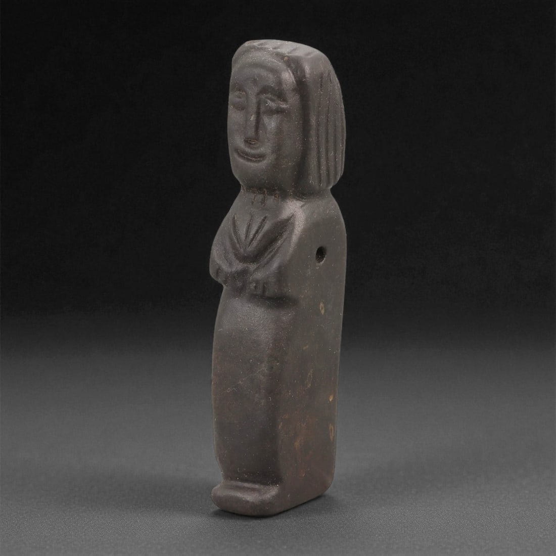 A Sino-Siberian Stone Idol, Medieval Period, 68LD: Carved from a dark brown stone with a smoothly worn surface, the figure is shown standing with a rounded head and a slightly tapering lower body. The facial features are defined by recessed eyes, a li