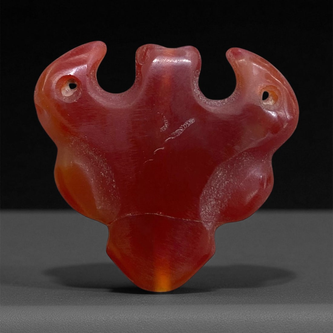 Ancient Bactrian Carnelian Double-Headed Amulet, c. 2nd-1st Millennium BCE, 2.5cm, 6g, 43AA: This rare double-headed amulet, carved from radiant red-orange carnelian, originates from the ancient Bactrian region (modern northern Afghanistan and Central Asia), c. 2nd-1st millennium BCE. Exhibit