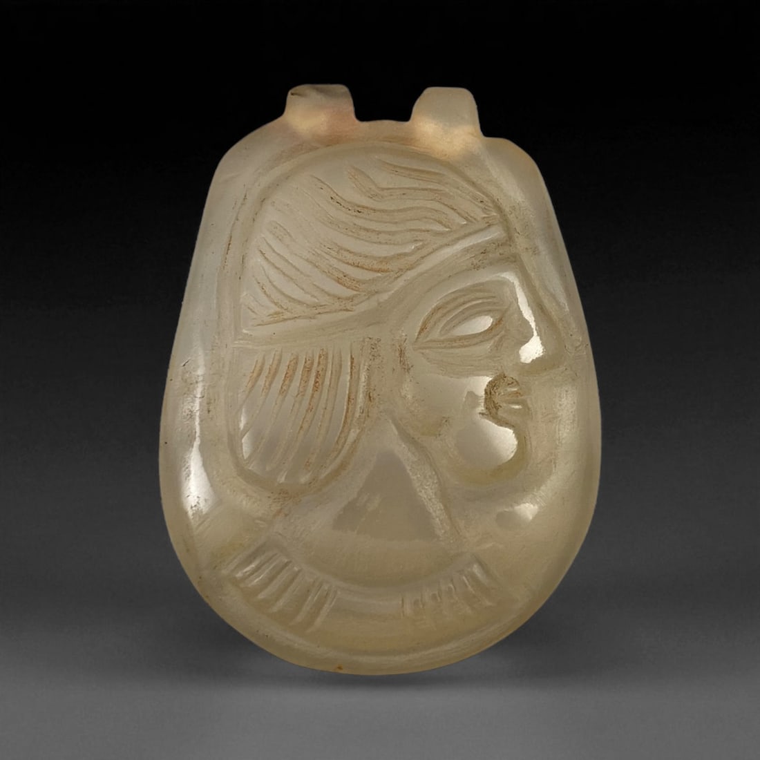 Ancient Parthian Chalcedony Amulet with Male Bust, c. 1st Century BCE - 2nd Century CE 55mm, 83BF: This exceptional translucent chalcedony amulet from the Parthian Empire depicts a finely carved male bust in profile, rendered with distinctive stylization characteristic of Parthian portraiture. The 