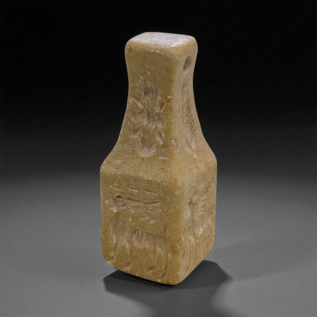 Ancient Indus Valley Steatite Animal Relief Amulet, c. 2500-2000 BCE, 6cm, 54g, 42BB: This intriguing amulet, carved from pale steatite, dates to the Indus Valley Civilization, circa 2500-2000 BCE. Its square-bodied form rising into a gently narrowed neck displays low-relief depictions