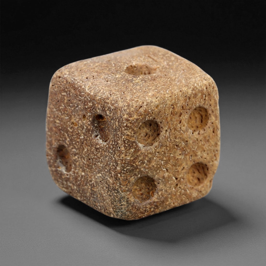 Ancient Roman Gaming Bone Dice, c. 1st-3rd Century CE 1.3cm, 77ES: This ancient Roman gaming die, carved from dense bone, reflects the enduring spirit of play and strategy within Roman daily life. Dice like this were used in taverns, private homes, and military encam