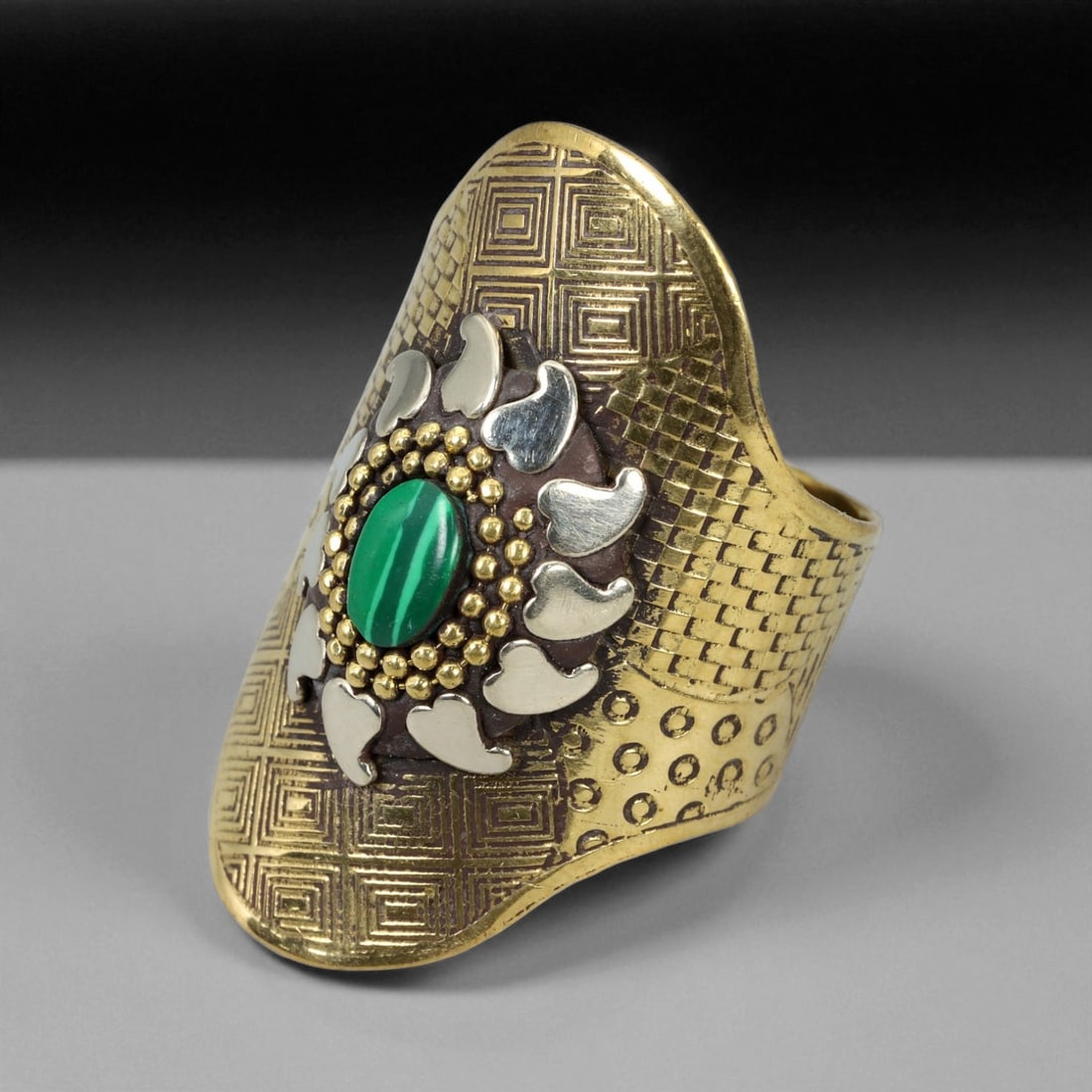 Vintage Himalayan Tribal Malachite Brass Ring, 20th Century, US Size 10.5, 53XD: This commanding vintage Himalayan ring reflects the region's tradition of transforming symbolic artistry into bold wearable forms. Crafted in brass, it features a central oval malachite cabochon set w
