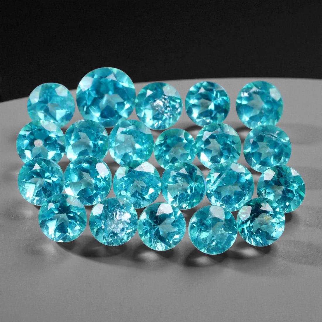 7.31 Carats Neon Blue Paraiba Color Topaz Parcel - Natural Stones - 4 mm, 5XE: This dazzling parcel of round-cut topaz gems radiates with a vivid neon blue hue reminiscent of the prized Paraiba tourmaline. Their intense color saturation, paired with brilliant faceting, delivers 