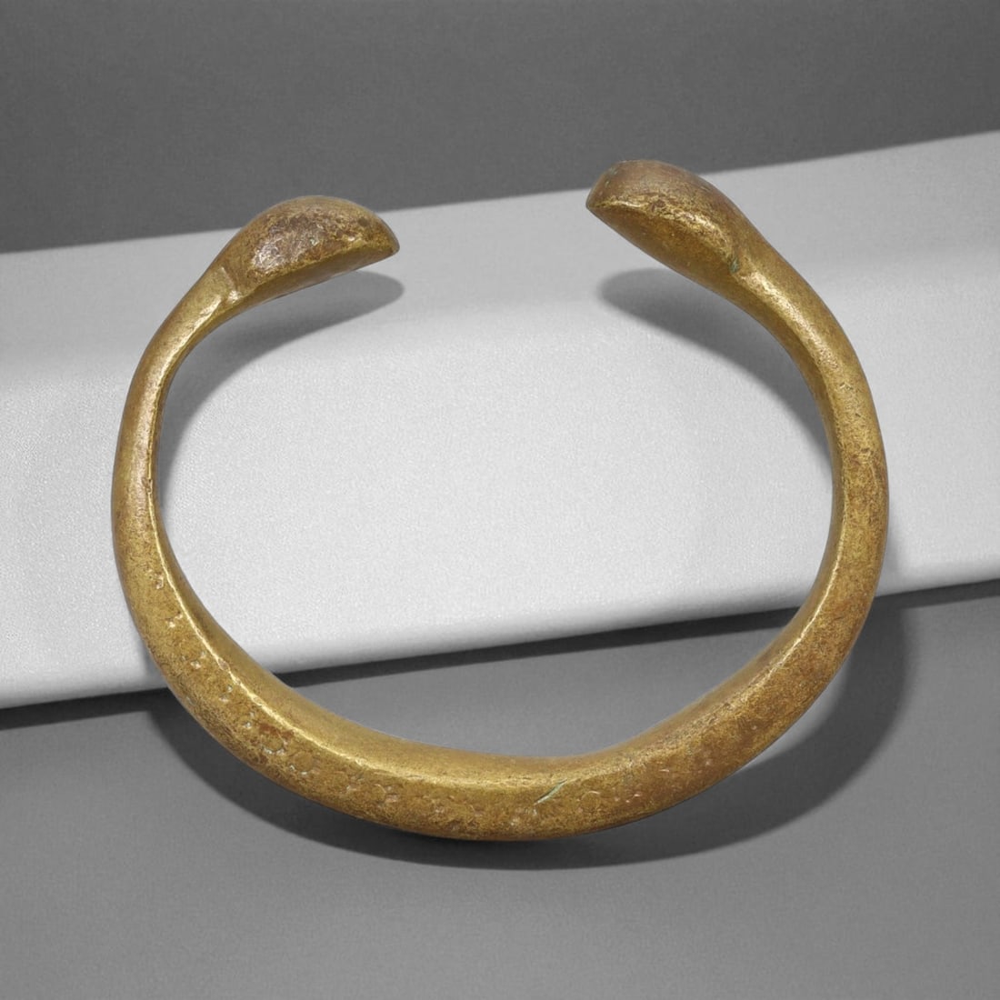 A West African Royal Manilla Currency Bracelet Symbolic Bronze Form, 19th Century, 7cm, 104g, 79X: This powerful A currency bracelet, known as a manilla, originates from West Africa and dates to the 19th century. Heavy, closed-ended forms like this were often used not only in trade but also as symb
