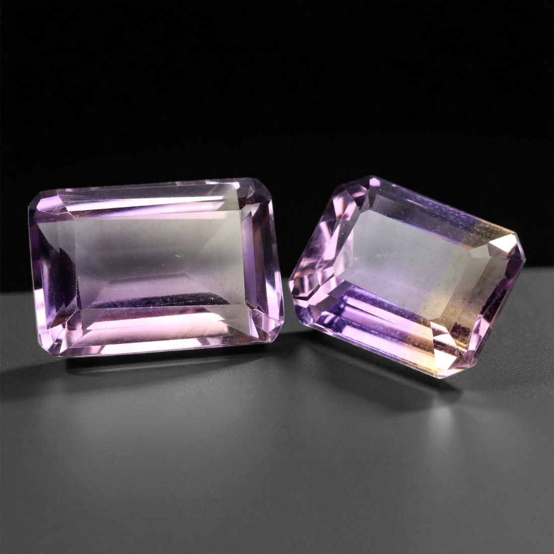17.43 Carats Bi-Color Ametrine Emerald Cut Pair - Natural 2-Piece Lot, 1.3 to 1.8 cm, 27XE: This elegant ametrine pair glows with a gentle interplay of soft lilac and golden champagne hues-showcasing the natural union of amethyst and citrine within a single crystal. Each stone is precision-c